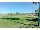 Beautiful putting green with golfers enjoying a sunny day surrounded by lush landscaping and mature trees at 6621 The Masters Ave, Lakewood Ranch, FL 34202