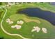 Picturesque aerial view of a challenging golf course with strategically placed sand traps and a tranquil lake at 6621 The Masters Ave, Lakewood Ranch, FL 34202