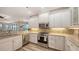 Bright kitchen with modern appliances, white cabinets, and a backsplash at 6621 The Masters Ave, Lakewood Ranch, FL 34202