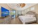 Bright main bedroom features a tray ceiling, wood floors, pool views, and a decorative windmill ceiling fan at 6621 The Masters Ave, Lakewood Ranch, FL 34202