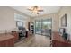 Home office with wood floors, a ceiling fan, sliding doors to the patio, and built-in bookshelves at 6621 The Masters Ave, Lakewood Ranch, FL 34202