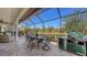 A long patio has a covered section with seating and dining with a clear view of the lake beyond at 6621 The Masters Ave, Lakewood Ranch, FL 34202