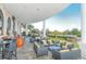 Inviting outdoor patio with comfortable seating, stone flooring, and scenic views of the surrounding landscape and water feature at 6621 The Masters Ave, Lakewood Ranch, FL 34202