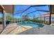A screened-in pool with brick patio overlooks the lake at 6621 The Masters Ave, Lakewood Ranch, FL 34202