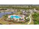 Aerial view of a community pool, clubhouse, and water feature surrounded by mature trees at 7036 Whittlebury Trl, Lakewood Ranch, FL 34202