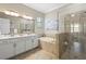 Bathroom with dual sink vanity, soaking tub, glass enclosed shower and tiled floor at 7036 Whittlebury Trl, Lakewood Ranch, FL 34202