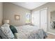 Cozy bedroom with neutral walls, plush bedding, and a closet with sliding doors at 7036 Whittlebury Trl, Lakewood Ranch, FL 34202