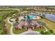 Aerial view of community clubhouse, pool, and amenities with lush landscaping and beautiful homes in the background at 7036 Whittlebury Trl, Lakewood Ranch, FL 34202