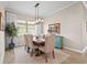 Dining room featuring a neutral color scheme, stylish lighting, and a large window at 7036 Whittlebury Trl, Lakewood Ranch, FL 34202
