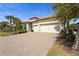 Stunning home features a tile roof, three-car garage, and a beautifully brick paver driveway and landscaping at 7036 Whittlebury Trl, Bradenton, FL 34202