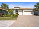 Beautiful home with a three-car garage, paver driveway, lush landscaping, and a terracotta roof at 7036 Whittlebury Trl, Lakewood Ranch, FL 34202