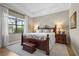 Bedroom with tray ceilings, a large window, wood furniture, and comfortable decor at 7036 Whittlebury Trl, Lakewood Ranch, FL 34202