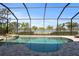 Inviting screened-in pool area with brick pavers, spa, and tranquil water views, perfect for relaxation and entertaining at 7036 Whittlebury Trl, Lakewood Ranch, FL 34202