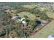 Expansive aerial view of estate with lush landscaping, pond, and horse pastures within property lines at 7108 229Th E St, Bradenton, FL 34211