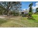 Expansive backyard with a large shady tree, fence and well-maintained grassy area at 7108 229Th E St, Bradenton, FL 34211