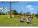 A backyard featuring a fire pit, chairs, kayaks and lush green grass at 7108 229Th E St, Bradenton, FL 34211