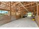 Rustic barn interior with wooden stalls, concrete floor, and ample lighting at 7108 229Th E St, Bradenton, FL 34211