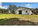 Barn with white walls, metal roof, and sliding doors, surrounded by a green lawn and wooden fencing at 7108 229Th E St, Bradenton, FL 34211