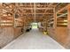 Inside view of barn with wooden horse stalls, overhead lighting, concrete floors, and open doors at the end at 7108 229Th E St, Bradenton, FL 34211