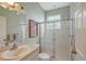 Bright bathroom with white tile, glass shower doors, and a framed art piece at 7108 229Th E St, Bradenton, FL 34211