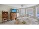 Relaxing bedroom featuring a decorative bedspread, a large flatscreen TV, and views of the fenced in backyard at 7108 229Th E St, Bradenton, FL 34211