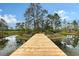 A long wooden dock extends over the water, offering a tranquil pathway to a serene pond at 7108 229Th E St, Bradenton, FL 34211