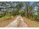 Long private driveway lined with trees and lush foliage, creating a picturesque and secluded entrance to the property at 7108 229Th E St, Bradenton, FL 34211