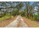 A long driveway is lined with trees and landscaping, offering a scenic route to the property at 7108 229Th E St, Bradenton, FL 34211