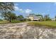 Rear exterior showing a house with a screened porch and attached garage on a lot with a sandy drive at 7108 229Th E St, Bradenton, FL 34211