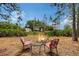 A cozy fire pit area with chairs invites relaxation and gatherings in a peaceful, wooded setting at 7108 229Th E St, Bradenton, FL 34211