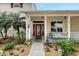 Charming front entrance with a red door, decorative plants, and a welcoming porch at 7108 229Th E St, Bradenton, FL 34211