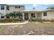 Inviting home exterior with vibrant flowerbeds, lush greenery, and a red front door at 7108 229Th E St, Bradenton, FL 34211