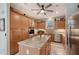 Bright kitchen with a center island, tile floors, stainless steel appliances, and ample cabinet space at 7108 229Th E St, Bradenton, FL 34211