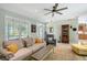 Bright living room with large windows, neutral decor, and a ceiling fan at 7108 229Th E St, Bradenton, FL 34211
