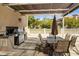 Outdoor kitchen with built-in grill and sink, plus a covered dining area at 7612 Lake Vista Ct # 406, Lakewood Ranch, FL 34202