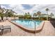 Inviting pool surrounded by a brick patio, lounge seating and manicured bushes at 770 S Palm Ave # 203, Sarasota, FL 34236