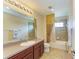 Well-lit bathroom with a dark wood vanity, a large mirror, and a shower-tub combo at 8124 115Th E Ave, Parrish, FL 34219