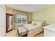 Serene bedroom with a window view, neutral tones, and a bench at the end of the bed at 8124 115Th E Ave, Parrish, FL 34219