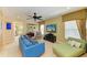 Comfortable living area with a TV, blue sofa, green chaise lounge, and neutral decor at 8124 115Th E Ave, Parrish, FL 34219