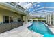 Covered patio with an outdoor kitchen and comfortable seating next to a pool at 8124 115Th E Ave, Parrish, FL 34219