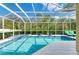 Inviting screened pool area with spa, sun loungers, and lush landscaping at 8124 115Th E Ave, Parrish, FL 34219