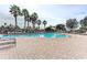 Inviting community swimming pool, surrounded by lounge chairs and palm trees, under a bright blue, partially clouded sky at 8124 115Th E Ave, Parrish, FL 34219