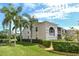 Inviting condo building featuring lush landscaping, manicured lawn, and stately palm trees at 8951 Veranda Way # 621, Sarasota, FL 34238