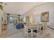 Open-concept living and dining area with neutral carpet, chandelier and sliding glass doors to the lanai at 8951 Veranda Way # 621, Sarasota, FL 34238