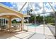 View of the community pool from a screened lanai featuring seating at 8951 Veranda Way # 621, Sarasota, FL 34238