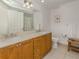 Bathroom with double vanity, wood cabinets, and tiled floors at 100 Central Ave # C521, Sarasota, FL 34236