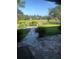 Lush backyard overlooking the golf course, with a stone pathway and serene landscaping at 10157 Sunburst Ct, Spring Hill, FL 34608