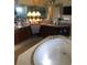 Open Primary bathroom featuring dual sinks, a separate soaking tub, and a large decorative mirror at 10157 Sunburst Ct, Spring Hill, FL 34608