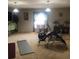 This bonus room features neutral carpeting, a TV, exercise equipment, and abundant natural light from the window at 10157 Sunburst Ct, Spring Hill, FL 34608