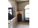 This entryway includes a dark wood door, neutral carpeting, large window, bench, and a lamp at 10157 Sunburst Ct, Spring Hill, FL 34608
